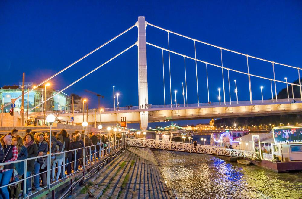 Touristen warten am Anleger auf abendliche Schifffahrt in Budapest