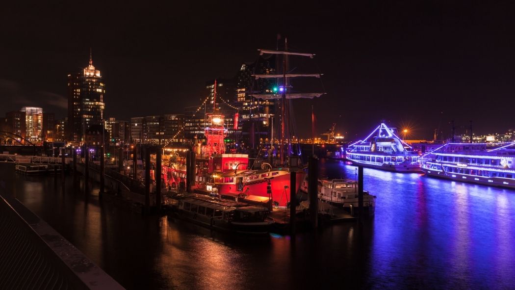 Schiffe im Hamburger Hafen leuchten in der Dunkelheit