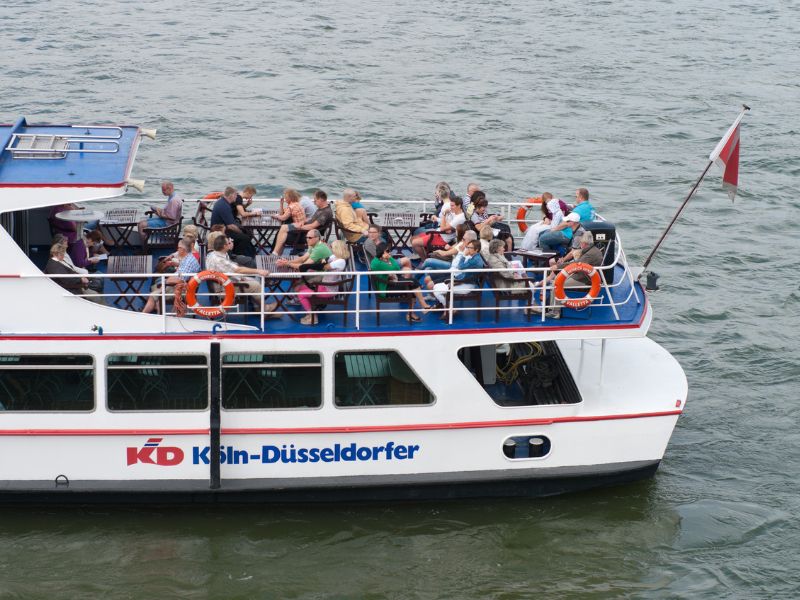 Touristen während einer Schiffsrundfahrt auf dem Rhein